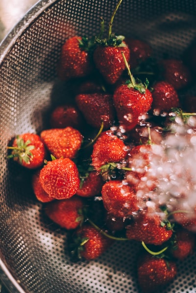 成熟的草莓放在灰色的钢制滤网上